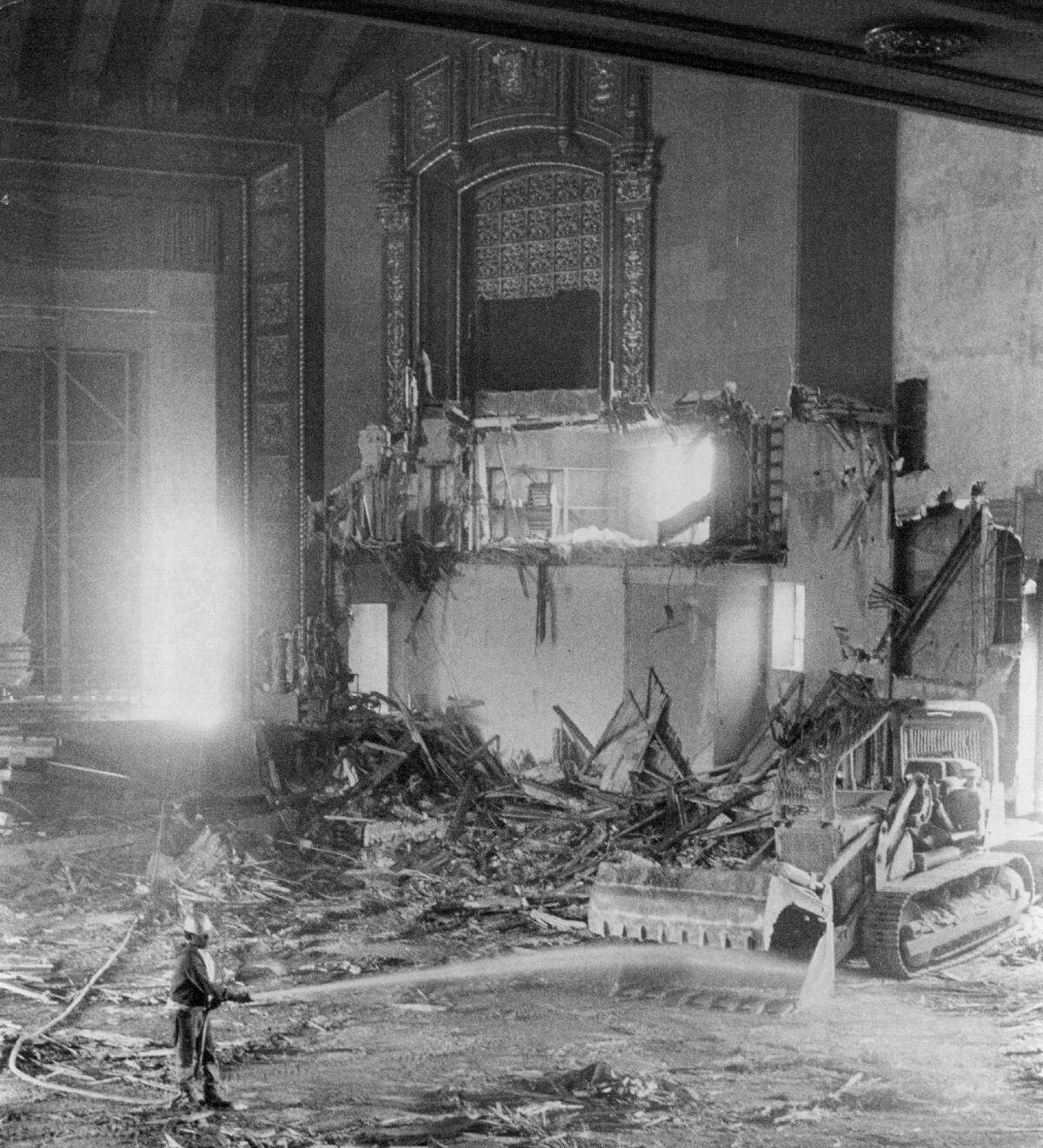 Some of the ornate interior details of East Sacramento’s Alhambra Theatre remain visible in June 1973, as a worker hoses down debris to settle the dust during its demolition.
