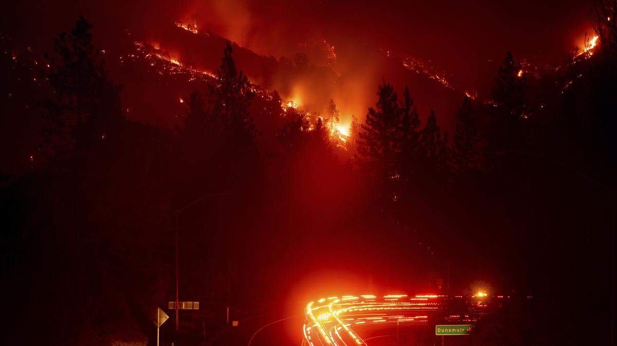 Fire trucks pass the Delta Fire burning in the Shasta-Trinity National Forest, Calif., on Wednesday, Sept. 5, 2018. A new California law aims to prevent people from being unable to evacuate from fires like this because their garage door won’t open. (AP Photo/Noah Berger)