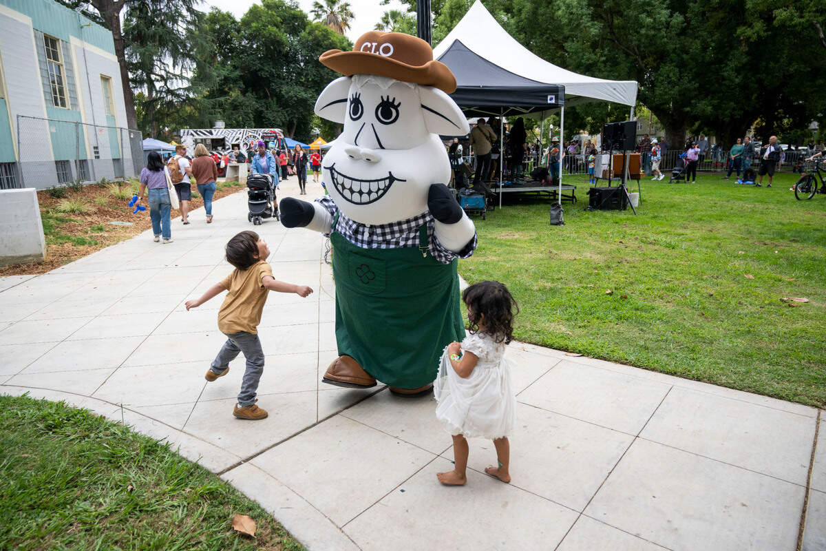 Clover Sonoma’s mascot, Clo the Cow, dances with kids during the 50th anniversary celebration of the Sacramento Natural Foods Co-op at Winn Park on Saturday.
