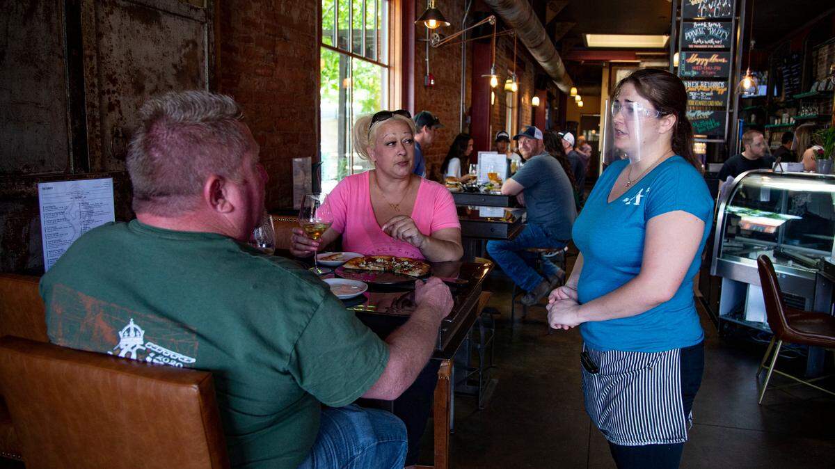 Mason McNay and Amber Bebben of Meadow Vista speak with their server Destinee Scott on Saturday, May 16, 2020, at the Auburn Alehouse Annex in Auburn. After months of restrictions, restaurants can add indoor seating capacity after Placer County moved into the state’s orange tier for COVID-19 risk.