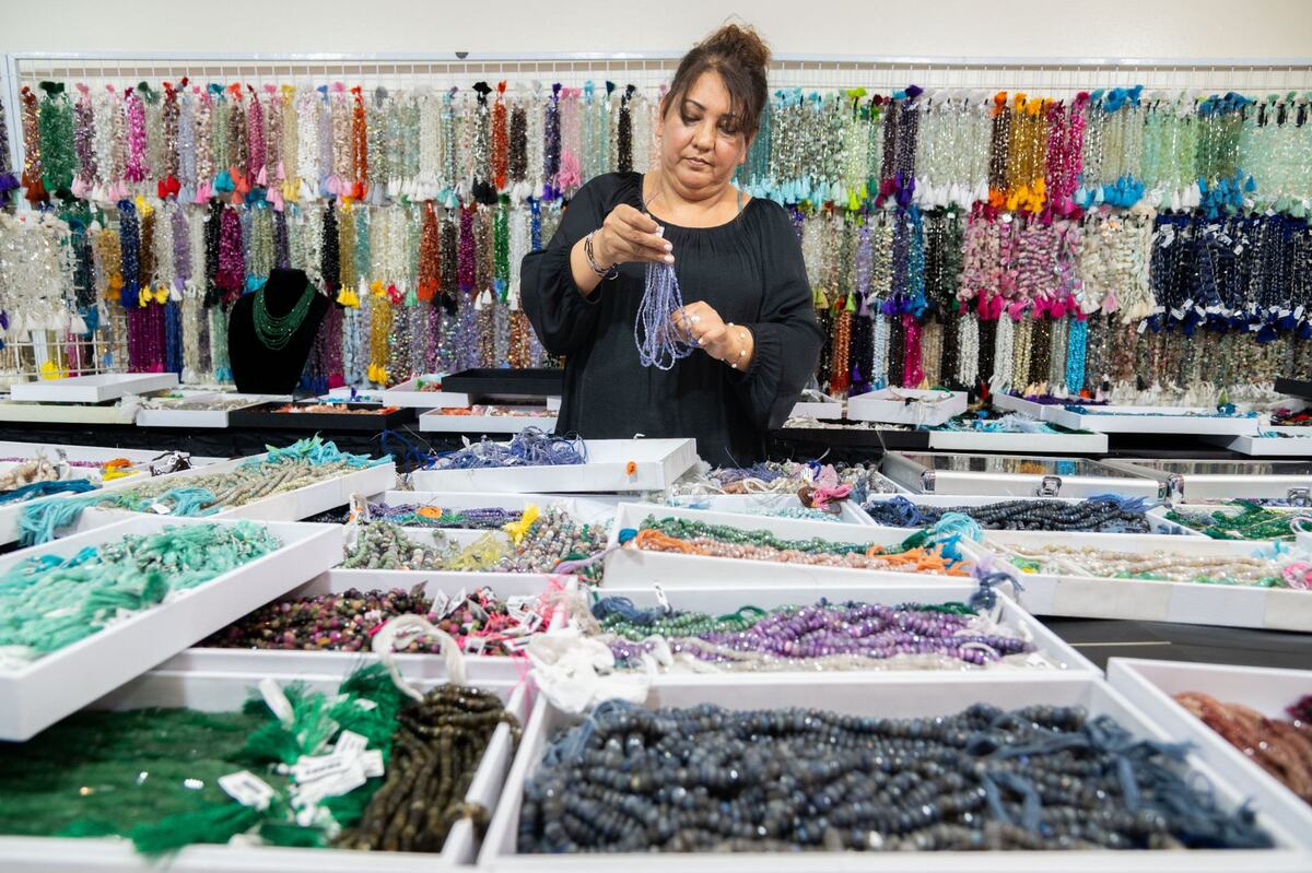 Naz Doost, co-owner of Zaza Gems, sorts beads during the Gem Faire at the Scottish Rite Masonic Center in Sacramento on Friday, Aug. 2, 2024. Doost said her favorite part of her job is explaining different gemstones to customers.