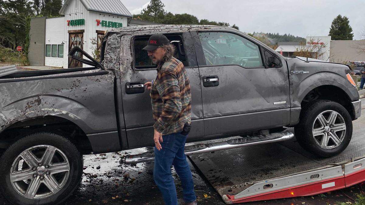 Myrl Wallace gets his Ford F-150 truck towed after a rare tornado touched down and flipped his pickup into a bank of trees in Scotts Valley on Saturday.