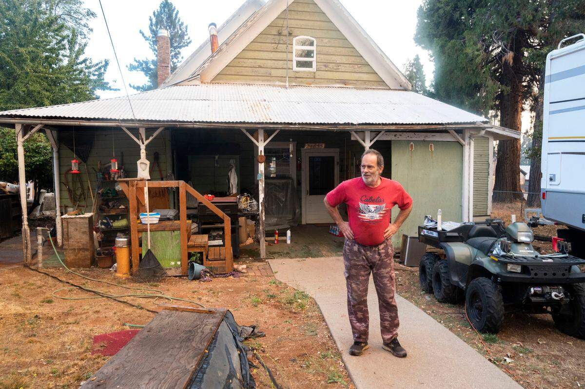 David Tachera, one of the few residents that stayed behind in Foresthill, stands in his back yard as firefighters fight the Mosquito Fire from the air and on the ground Tuesday, Sept. 13, 2022.