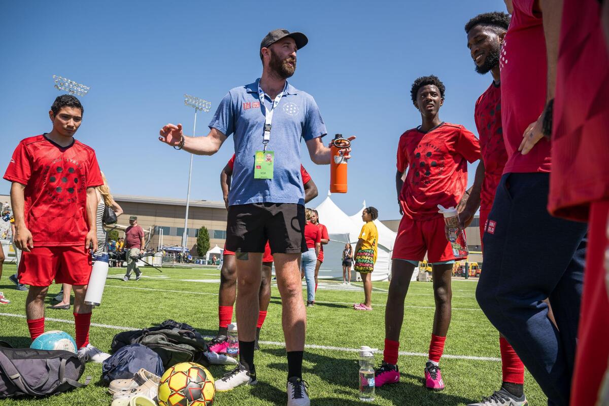 United States men’s coach Reed Fox, center, congratulates his players after their win over Indonesia, and advises them to stick around to watch the competition, on the opening day of soccer at the 18th Homeless World Cup on Saturday at Sacramento State’s Hornet Stadium. The event, first held in 2003, is being hosted in the United States for the first time this year following a hiatus during the COVID-19 pandemic.