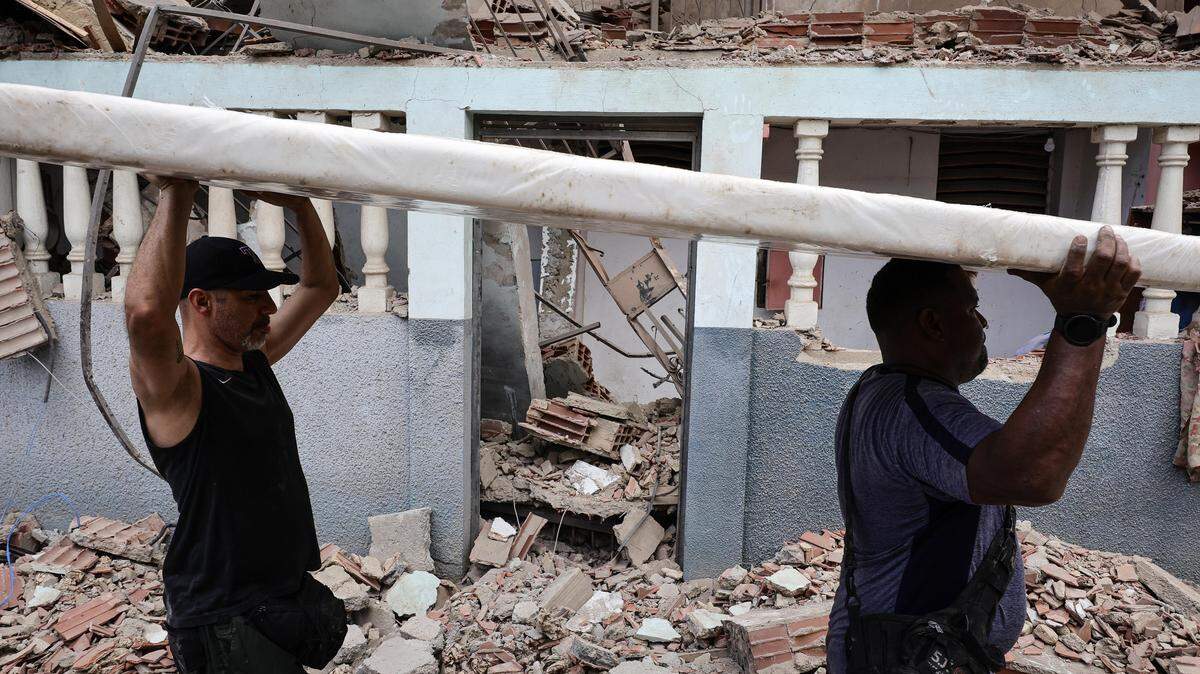 People remove belongings from an apartment building on Jan. 4 in a neighborhood of La Guaira, Venezuela, that residents said was damaged during U.S. military operations related to the capture of President Nicolas Maduro.