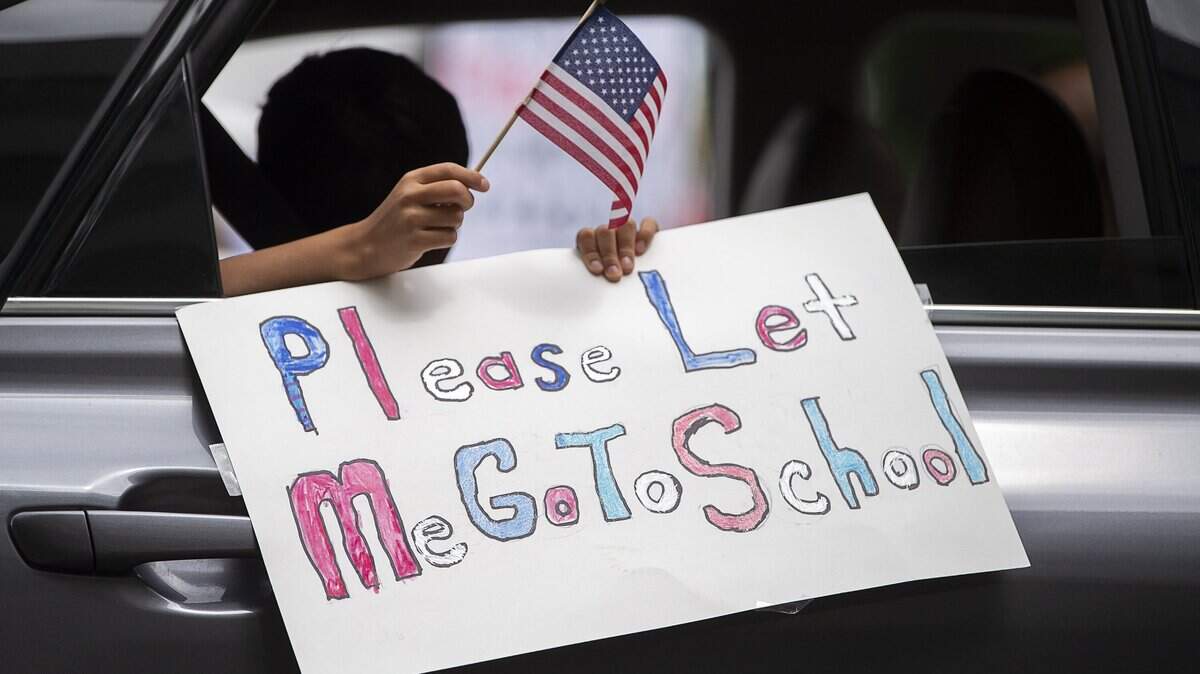 “Please let me go to school” reads a sign held by a child in a car that converged on the California Capitol in Sacramento on Monday, April 20, 2020, to join the protest against the state’s stay-at-home orders to slow the spread of the coronavirus.