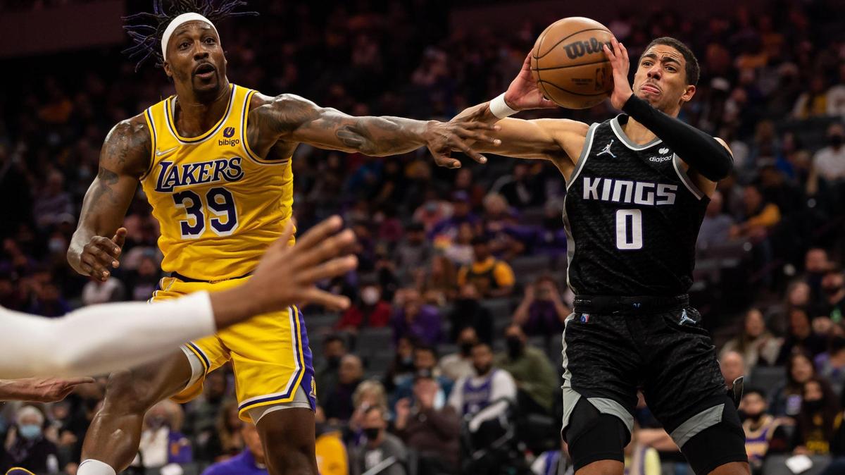 Sacramento Kings guard Tyrese Haliburton (0), right, passes around Los Angeles Lakers center Dwight Howard (39) during the second period of the NBA basketball game Tuesday, Nov. 30, 2021, at Golden 1 Center in Sacramento.