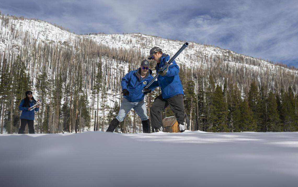 California Department of Water Resources engineers Jacob Kollen and Anthony Burdock, center, take the season's first snow survey measurements with hydrometeorologist Angelique Fabbiani-Leon, left, at Phillips Station in El Dorado County on Tuesday, Dec. 30, 2025.