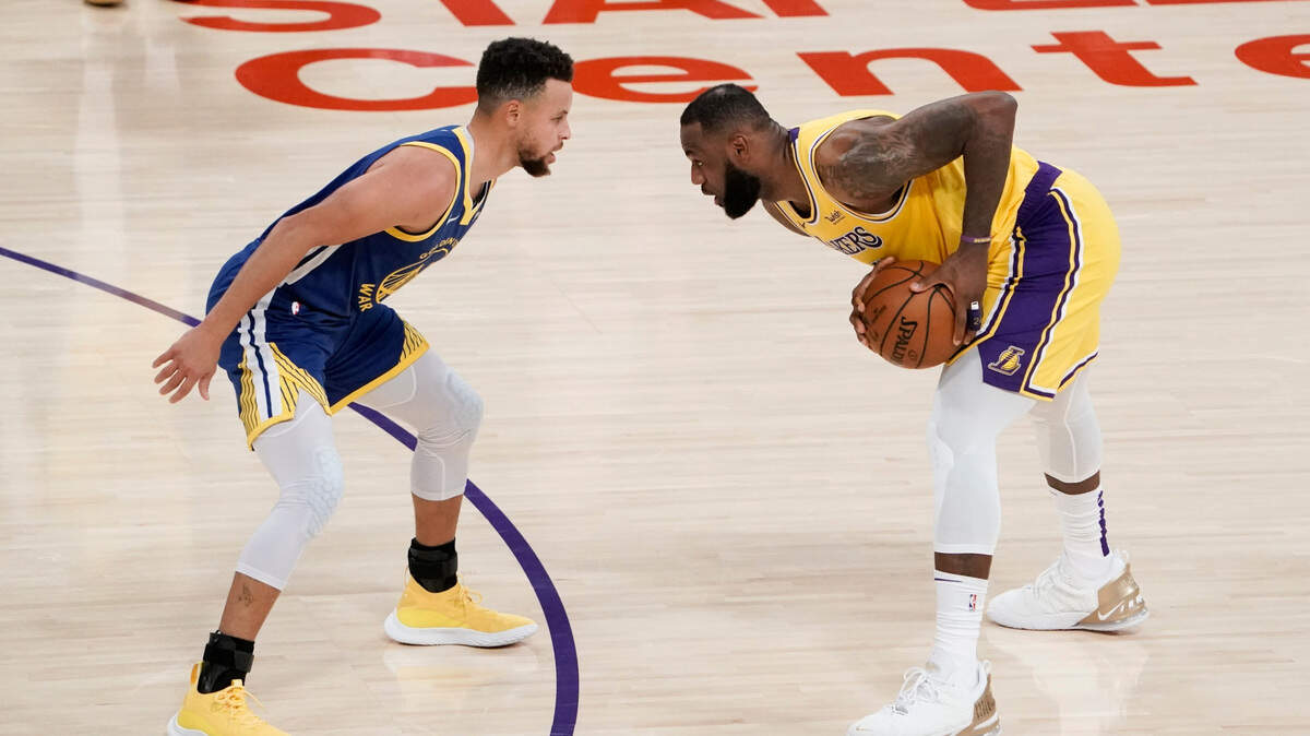 Golden State Warriors’ Stephen Curry, left, pressures Los Angeles Lakers’ LeBron James during the first half of an NBA basketball game, Monday, Jan. 18, 2021, in Los Angeles. (AP Photo/Jae C. Hong)