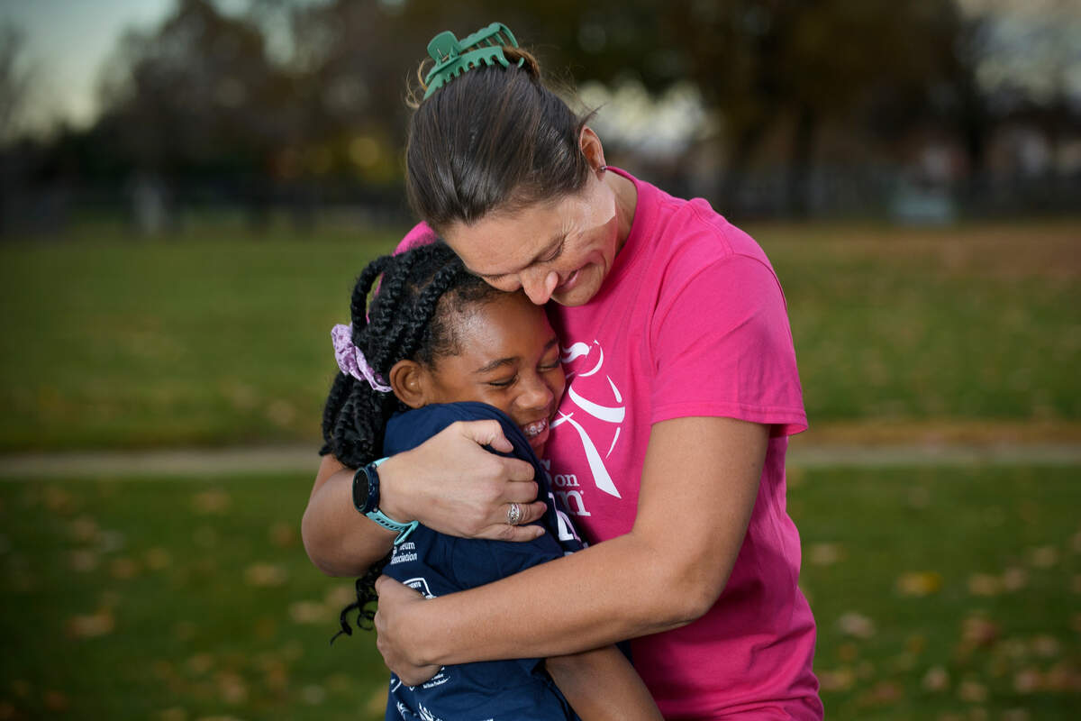 Girls on the Run of Greater Sacramento volunteer coach Candace Beam hugs Charlea Hill, 11, at Joseph Sims Elementary School in Elk Grove on Thursday, Dec. 1, 2022. Hill is one of several young ladies mentored in their program that culminates in a 5K run.