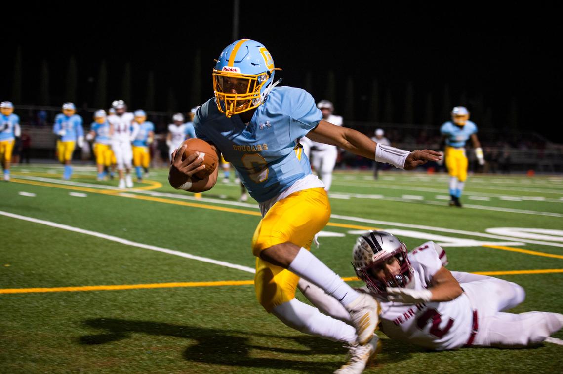 Center quarterback Michael Wortham evades a tackle by Bear River running back Colton Jenkins in 2019. 