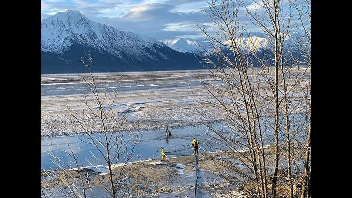 A surveyor stuck waist deep in mud flats near Girdwood was rescued by firefighters, Alaska officials say.