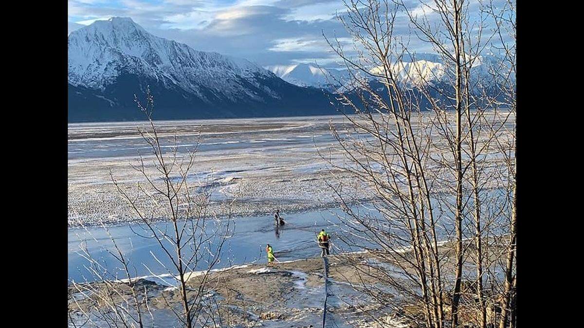 A surveyor stuck waist deep in mud flats near Girdwood was rescued by firefighters, Alaska officials say.
