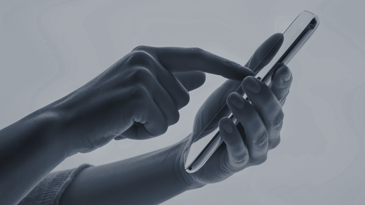 A person dialing on a cellphone.