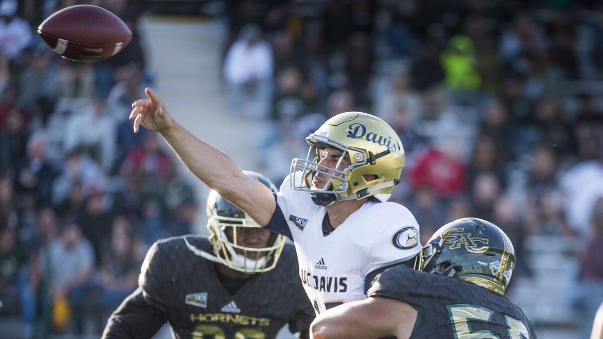 UC Davis Aggies quarterback Jake Maier (15) gets rid of the ball as he’s pressured by Sacramento State Hornets linebacker Manoah Pearson, right, in the Causeway Classic on Nov. 18, 2017 at Sacramento State.