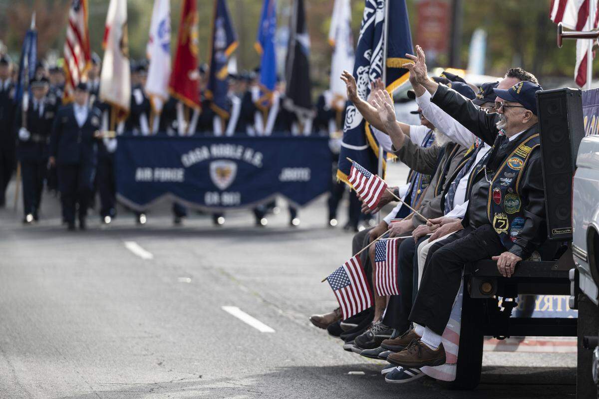 Veterans wave to the crowd as Casa Roble High School JROTC follows behind them during a Veterans Day parade in Folsom on Tuesday, Nov. 11, 2025.