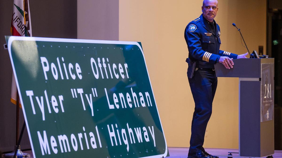Elk Grove Police Department Chief Bobby Davis looks over at a freeway dedication sign for Officer Tyler “Ty” Lenehan during an unveiling ceremony held by the city Tuesday, Jan. 17, 2023, at District 56 in Elk Grove. A city military banner was also unveiled to honor Lenehan, a motorcycle officer who was killed by a wrong-way driver Jan. 21, 2022, on Highway 99, where the freeway sign will hang.