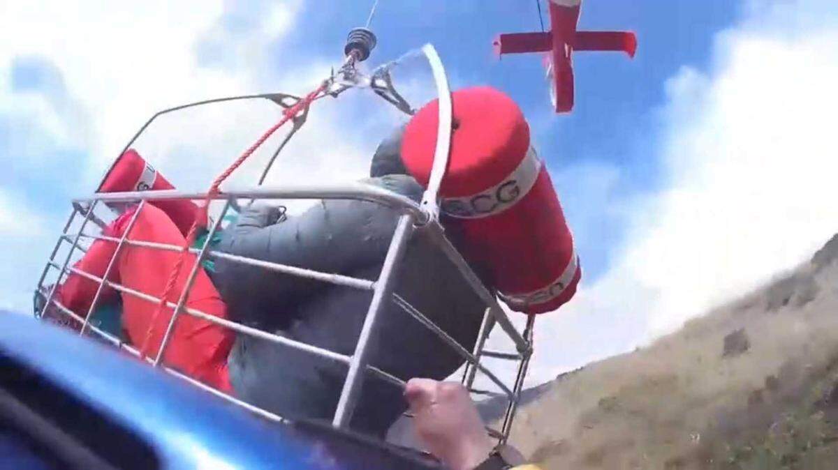 In an image taken from video, a rescue basket lifts up a hiker in distress along the Mendocino coast on Monday, May 25, 2026. The Coast Guard said it rescued two people after one of the hikers was injured.