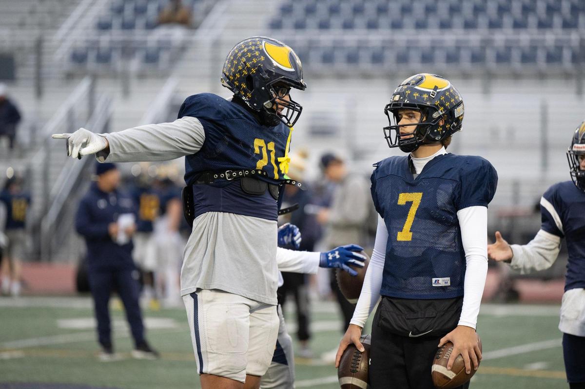 Oak Ridge Trojans tight end Kaleb Edwards (21) talks with quarterback Phoenix Hester (7) during practice on Tuesday in El Dorado Hills.
