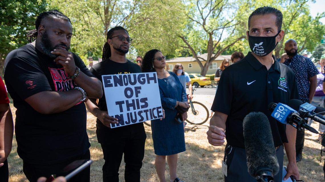 Activist Berry Accius, left, listens to Sacramento City Unified Superintendent Jorge Aguilar speak on Thursday, July 1, 2021, about Katherine Sanders, a teacher who used racially charged language in front of her students last month, during a press conference at Kit Carson International Academy in Sacramento.