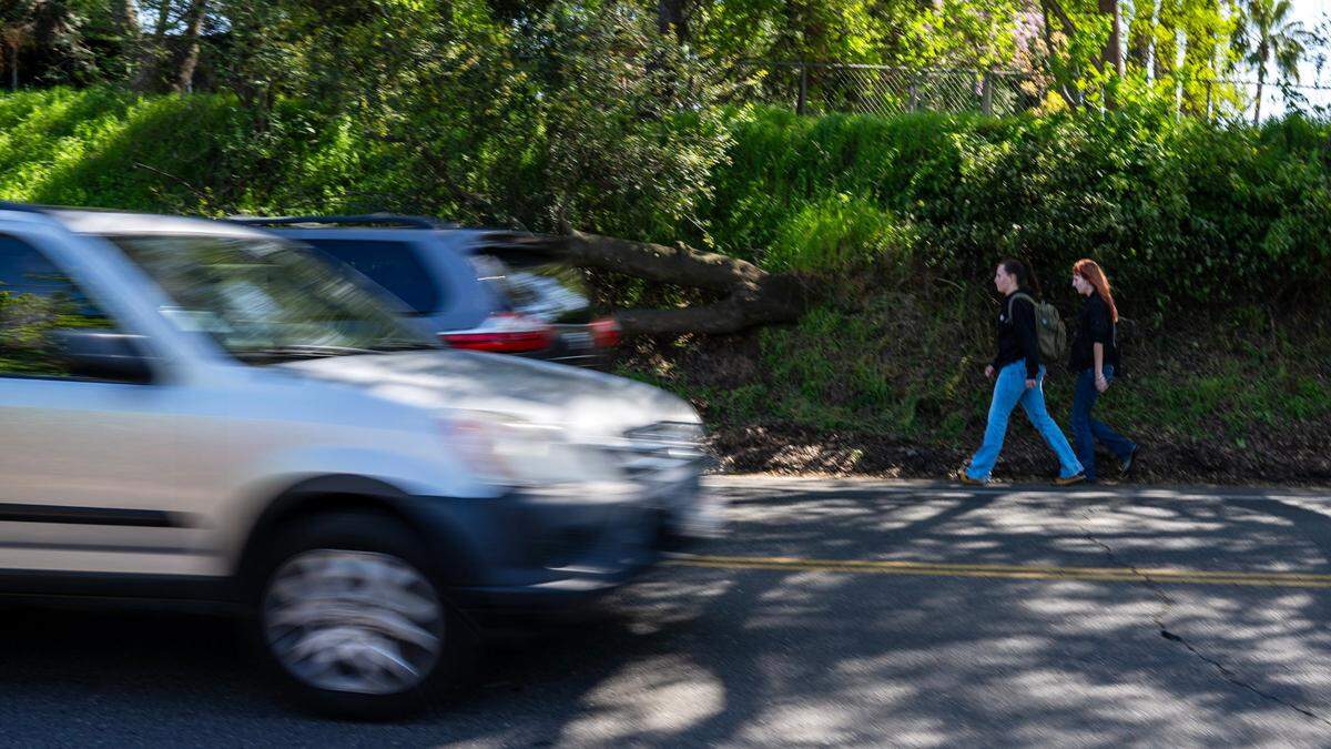 Jago Martin, 15, left, and her sister Adair, 18, walk in the bike lane on their way home after school on Sunset Avenue in Fair Oaks last month.