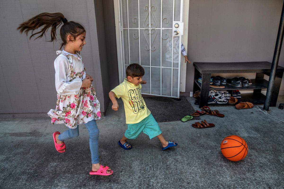 Afghans refugee Hasiba, 8, and her brother Abdullah, 4, play soccer with a basketball in front of a cousinís apartment in their new apartment complex. Hesiba, who will continue school in Sacramento, said she wants to work in law enforcement when she grows up. ìI like police,î she said with a big smile.