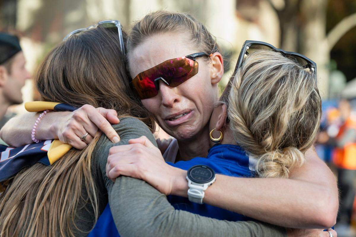 Stephanie Rouse, of San Francisco shows emotion as she hugs her teammates after finishing 11th for the women in the 40th California International Marathon from Folsom to the state Capitol in downtown Sacramento on Sunday, Dec. 3, 2023. “I just took them out there with me and every mile I had one of them on my shoulder,” Rouse said. “So to see them here at the end is really beautiful.”