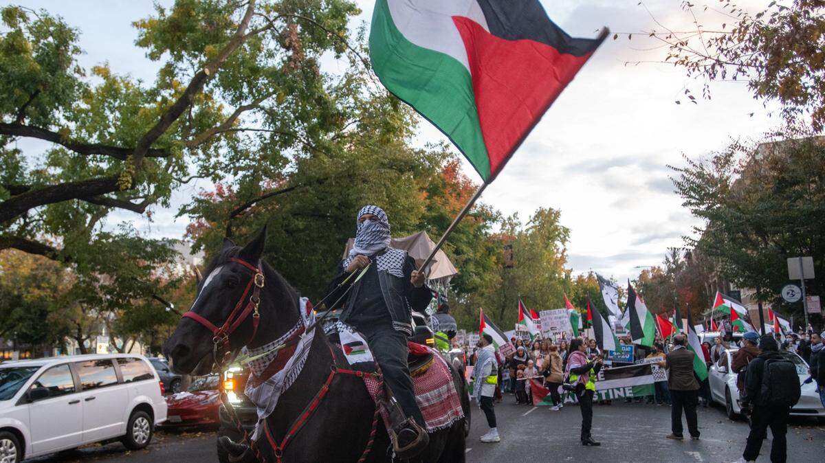 A demonstrator carrying the Palestinian flag rides a horse in front of a pro-Palestine march near the Memorial Auditorium in downtown Sacramento on Saturday, Nov. 18, 2023. The protesters were calling for a cease-fire in the Israel-Hamas war.