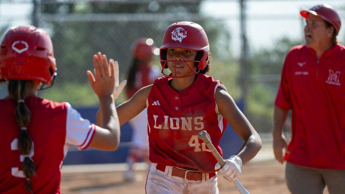 McClatchy Lions Jayeliza Rogers is congratulated by Elaina Salaguinto after scoring against the Folsom Bulldogs during a first-round CIF Sac-Joaquin Section Division I softball playoff game at Folsom High School on Wednesday in Folsom.
