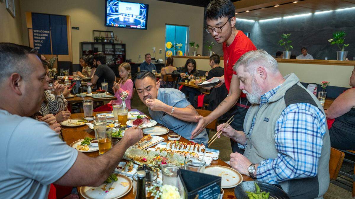 Waiter Cody Jie serves up sushi rolls to customers Travis Maley, right, and Chad Ortega, center, on Wednesday, Sept. 18, 2024, at Chef Frank Japanese Cuisine in North Natomas.