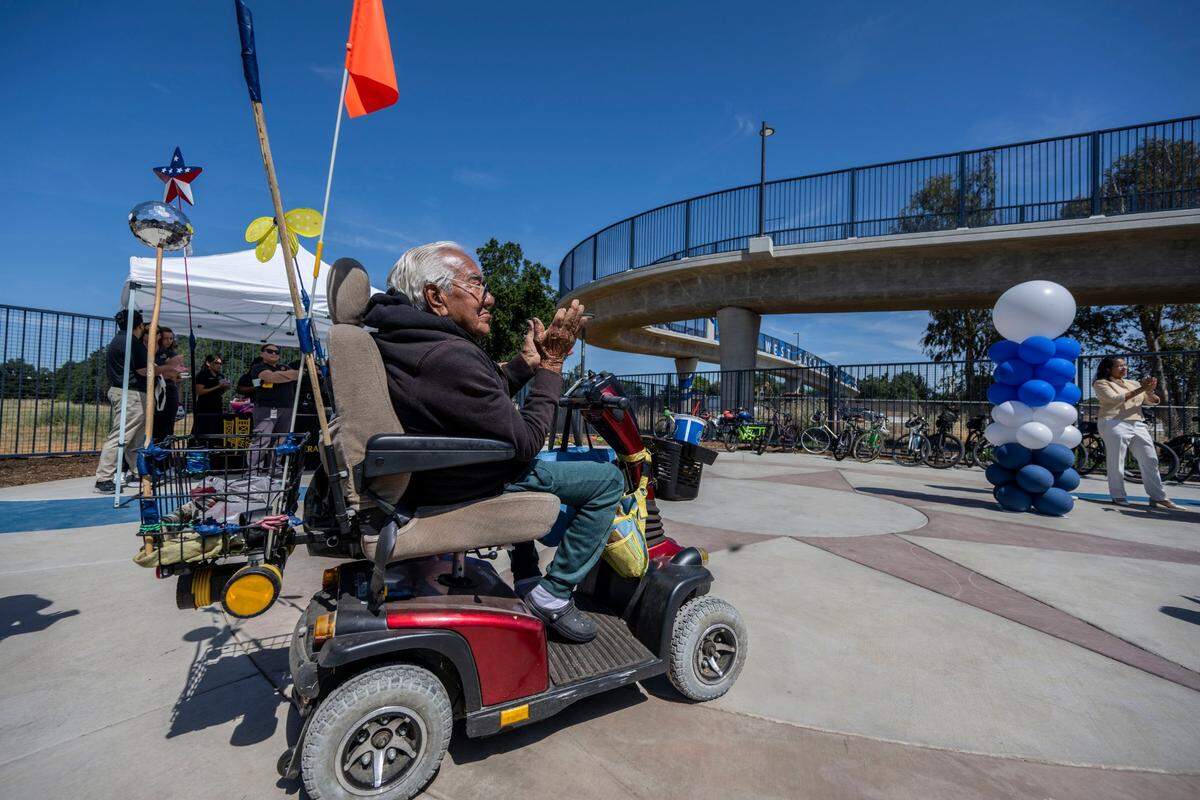 Tony Lopez, 84, of West Sacramento, claps for a speaker as he participates in the official opening of the Sycamore Trail pedestrian and cyclist overpass Thursday, May 29, 2025. Lopez said he’s happy that he will be able to visit his friends on the south side of West Sacramento by using the overpass.