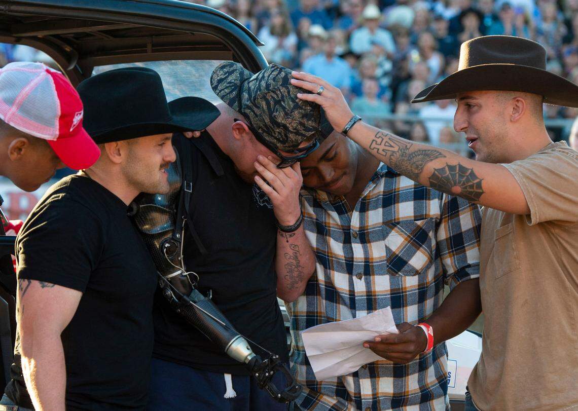 U.S. Marine Sergeant Tyler Vargas-Andrews, center, is consoled his Marine Corps “Brothers in Arms” Daulton Hannigan, Caden Cooper, and Jorge Mayo, who served in his unit in Kabul, as he’s moved to tears during a ceremony at the Folsom Pro Rodeo on Sunday.