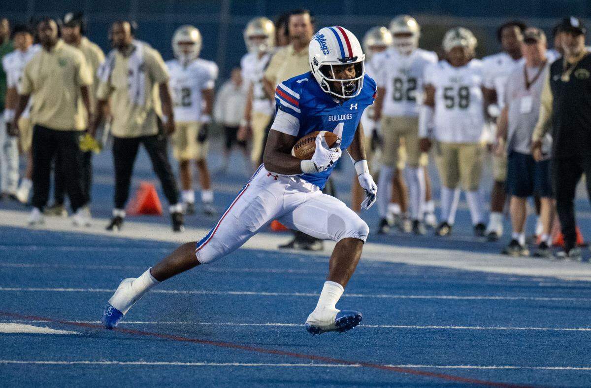 Folsom Bulldogs’ Carter Jackson (1) runs for a first down after a catch from quarterback Ryder Lyons against the Long Beach Poly Jackrabbits on Friday, Aug. 23, 2024, in Folsom. Folsom hosts Downey of Modesto this Friday in a CIF Sac-Joaquin Section Division I playoff matchup.