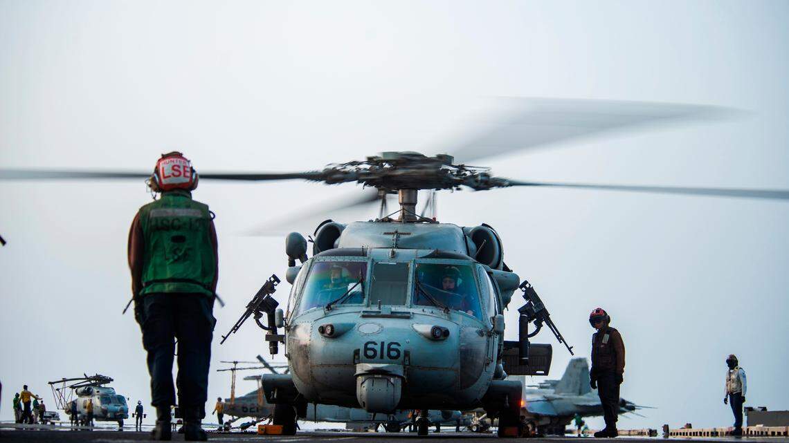 In this photo provided by the U.S. Navy, sailors on board an MH-60S Seahawk helicopter on the flight deck of aircraft carrier USS Ronald Reagan prepare to head to an oil tanker that was attacked off the coast of Oman in the Arabian Sea on Friday, July 30, 2021. An attack on an oil tanker linked to an Israeli billionaire killed two crew members off Oman in the Arabian Sea, authorities said Friday, marking the first fatalities after years of assaults targeting shipping in the region. (Mass Communication Specialist 2nd Class Quinton A. Lee/U.S. Navy, via AP)