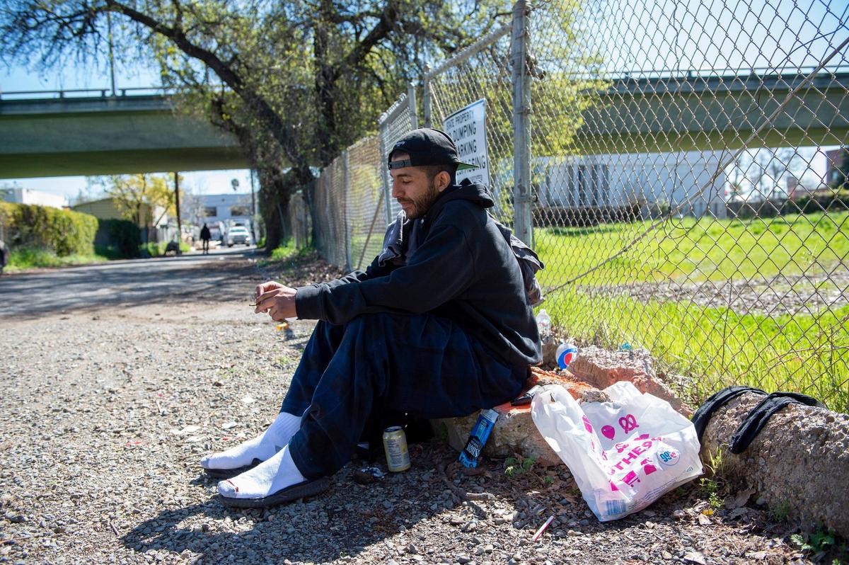 Ty Miller, who is experiencing homelessness, sits near a vacant lot, Thursday, March 21, 2019, where Sacramento City Councilmen Jay Schenirer and Steve Hansen are proposing the city open a homeless shelter between X Street and Broadway near Alhambra Boulevard.