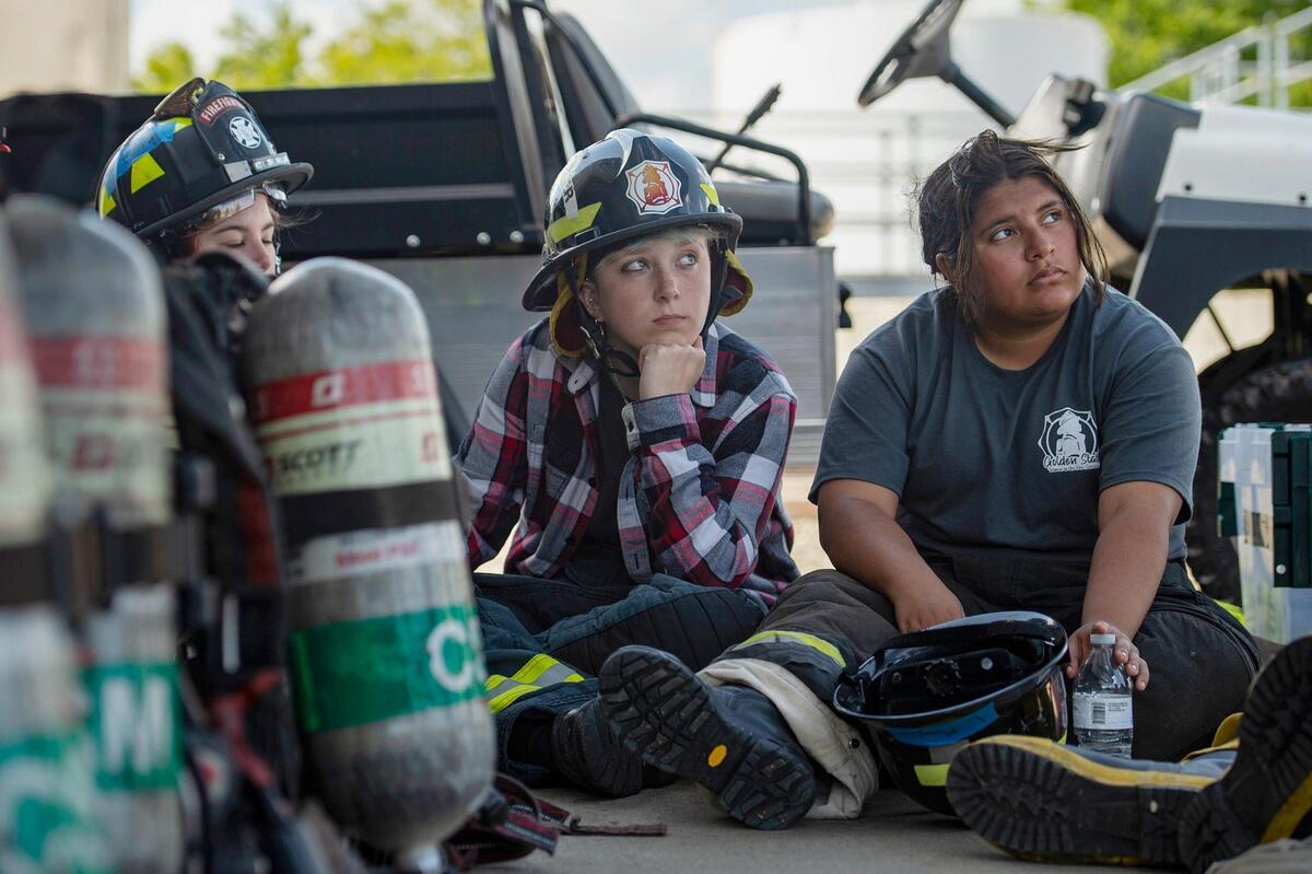 Cailei Caldera, center, 17, and Lacey Mayeux, right, 16, listen to a briefing before the search and rescue station during the HERo Girls Fire Camp, hosted by the Cosumnes Fire Department, on Sunday.