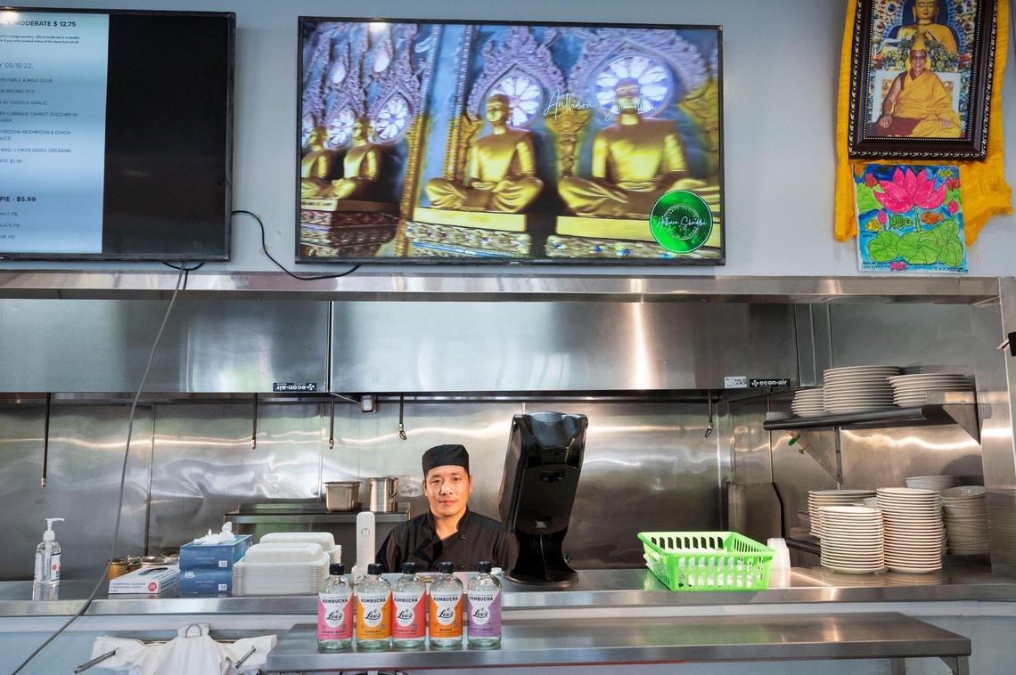 Luo Rong “Sam” Sang Zhu, executive chef and co-owner of Himalaya Vegan Organic Restaurant stands behind the counter earlier this month near a photo of the Dalai Lama. Born in Tibet, Sang Zhu was a monk for more than a decade before moving to Europe and then California, where he started working in the food industry.