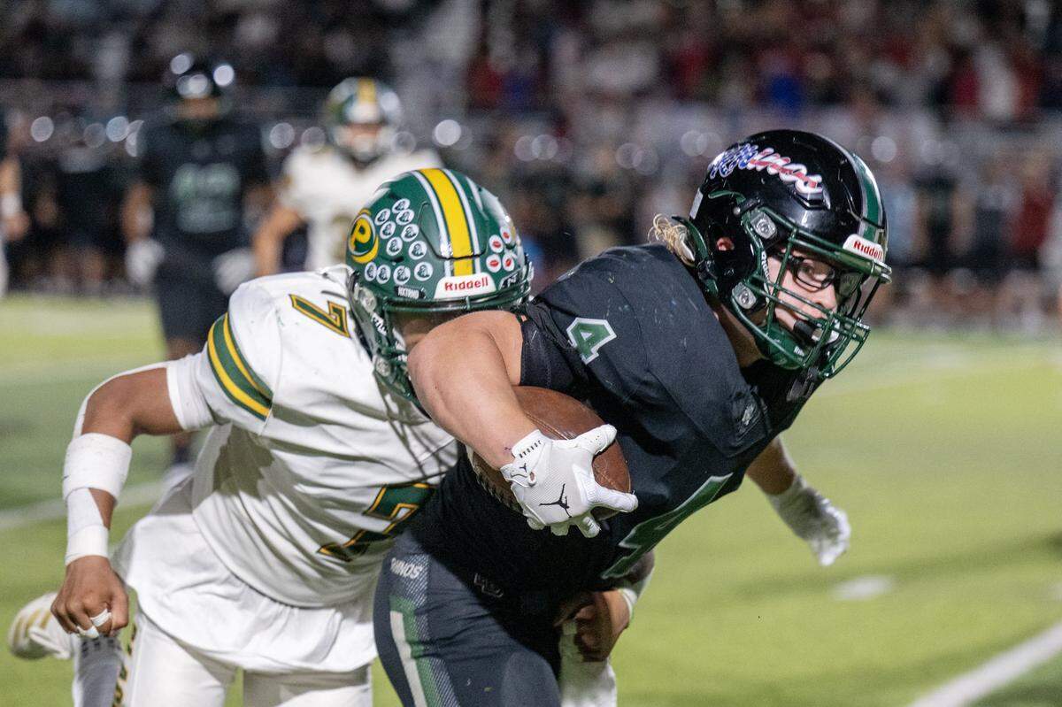 The Twelve Bridges Raging Rhinos' Chase Wyhlidko (4) is pursued by the Placer Hillmen's Ryan Alonzo (7) after a run in Lincoln in October. 