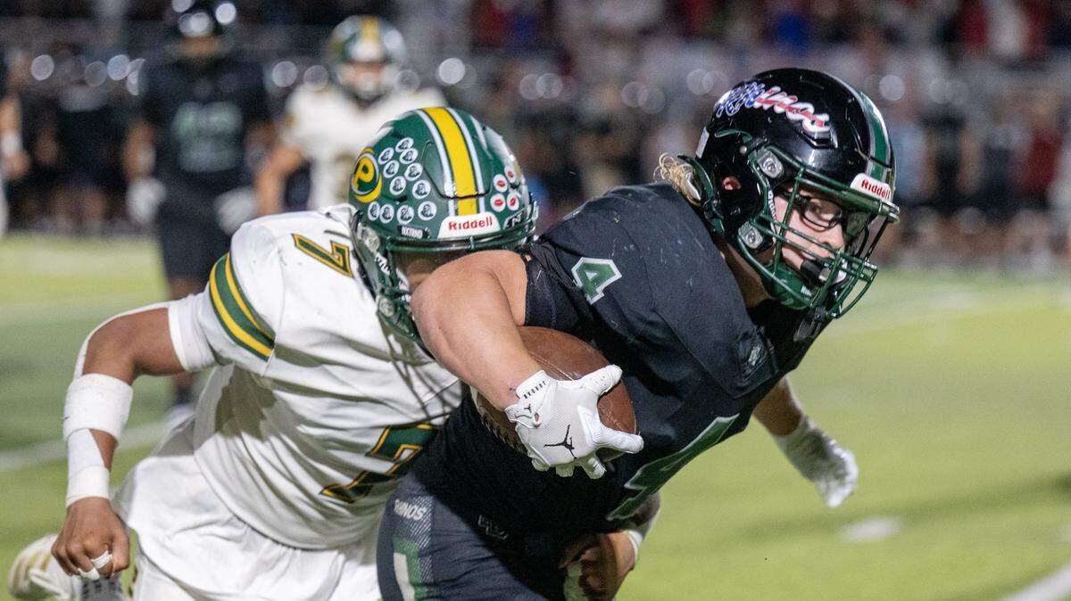 The Twelve Bridges Raging Rhinos' Chase Wyhlidko (4) is pursued by the Placer Hillmen's Ryan Alonzo (7) during a run in the second half on Friday in Lincoln. Wyhlidko rushed for three touchdowns.