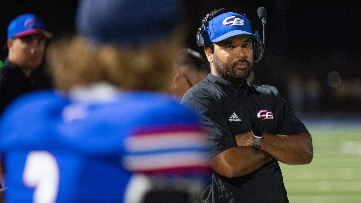 Christian Brothers coach Larry Morla looks toward Christian Brothers Falcons quarterback Deakon Holden on the sideline against Nevada Union in Sacramento on Sept. 5. Morla is on administrative leave. 
