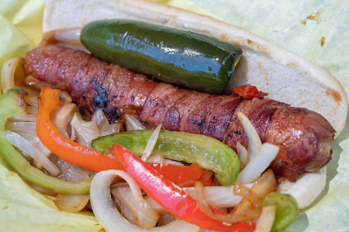 The bacon-wrapped hot dog is plated from Hot Doggin at the California State Fair on Sunday.