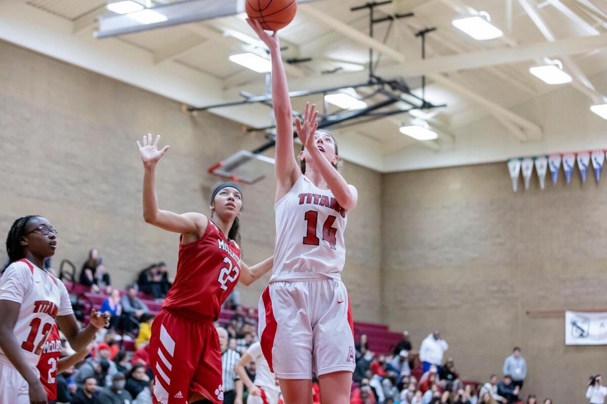 Antelope Titans forward Mary Carter (14) makes a layup past McClatchy Lions forward Nina Cain (22) to gain the lead 46-44 during the fourth quarter at the CIF Northern California Division II round two playoff game on Thursday, March 3, 2022, at Antelope High School. Carter had a double-double with 30 points and 10 rebounds. The Titans won 60-58.