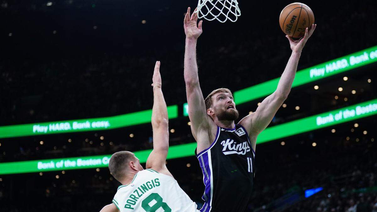 Jan 10, 2025; Boston, Massachusetts, USA; Sacramento Kings forward Domantas Sabonis (11) shoots against Boston Celtics center Kristaps Porzingis (8) in the first quarter at TD Garden. Mandatory Credit: David Butler II-Imagn Images