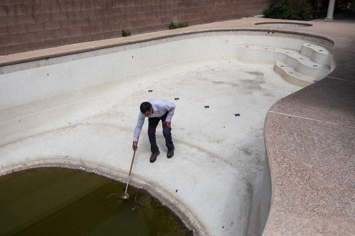 Rick Alvarez, vector control supervisor for the Delta Mosquito and Vector Control District, checks on an abandoned backyard pool in Tulare County that has become a breeding ground for mosquitoes.