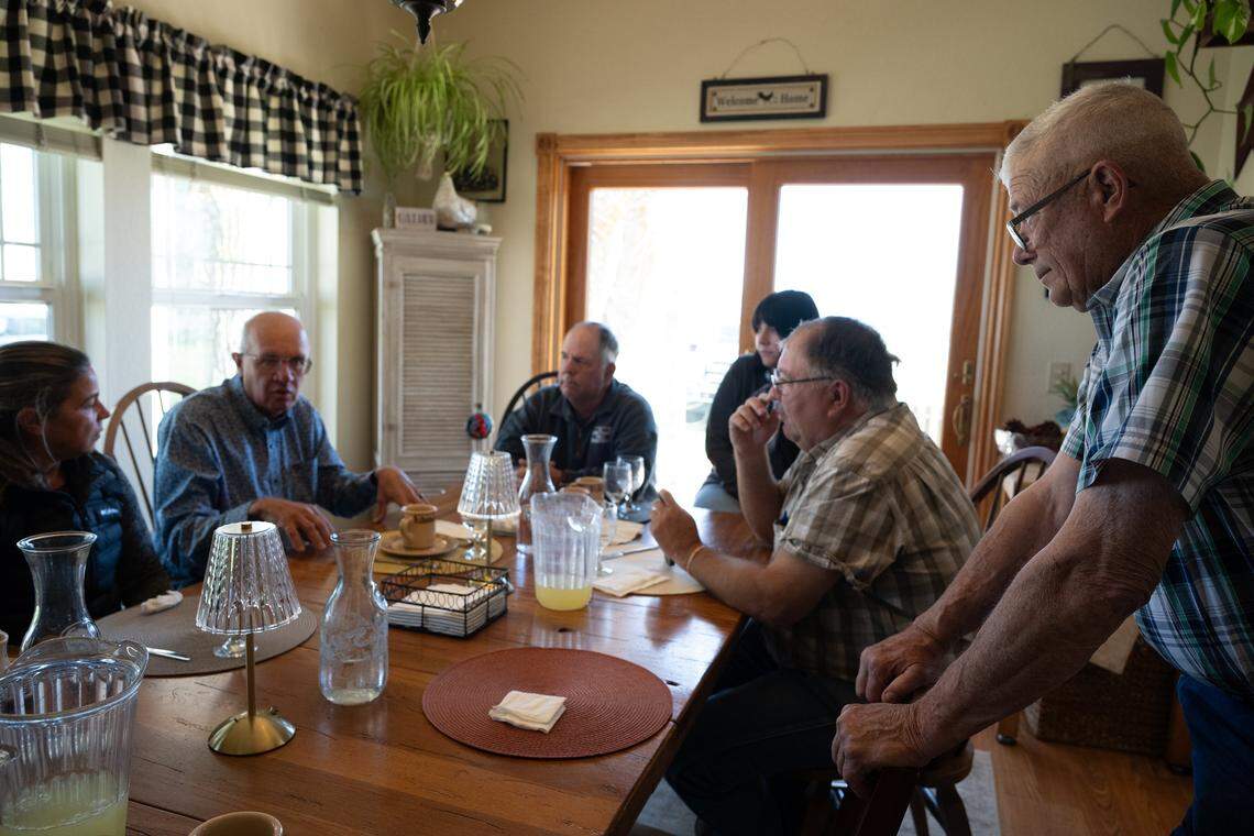 Plumas County Supervisor Dwight Ceresola, right, listens as UC Davis professors Tina Saitone, left, and Ken Tate, second from left, discuss a wolf study they are conducting, during a May meeting at the home of Rick Roberti in Sierra Valley. Rick Roberti is seated next to his daughter, Katie Roberti, alongside Sierra County Supervisor Paul Roen.