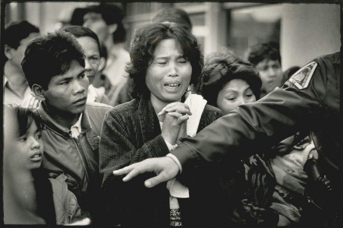 A tearful mother and other parents are barred by police on Jan. 18, 1989, outside Cleveland Elementary School before being reunited with their children in the Stockton school's auditorium after a school shooting.