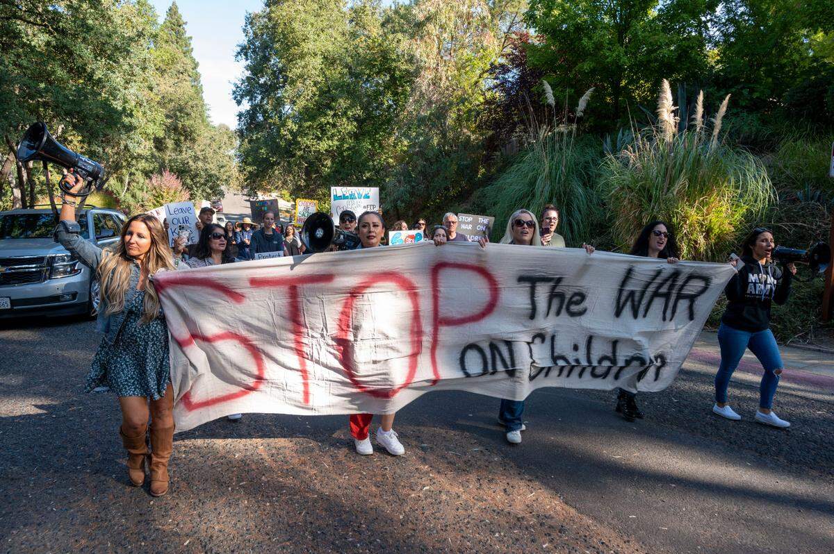 Tara Thornton, left, co-founder of Freedom Angels, holds a megaphone as parents’ rights activists rallied outside Gov. Gavin Newsom’s Fair Oaks home in 2023 to protest trans bills and what they call a “War on Children.”