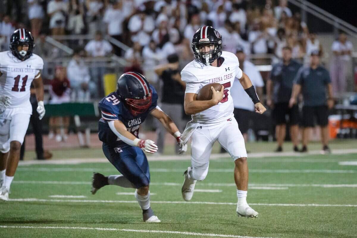 Laguna Creek Cardinals quarterback Mitchell Labrado (15) runs the ball before being tackled by Pleasant Grove Eagles linebacker Caden Bemis (24) in the second half of the game on Sept. 8.