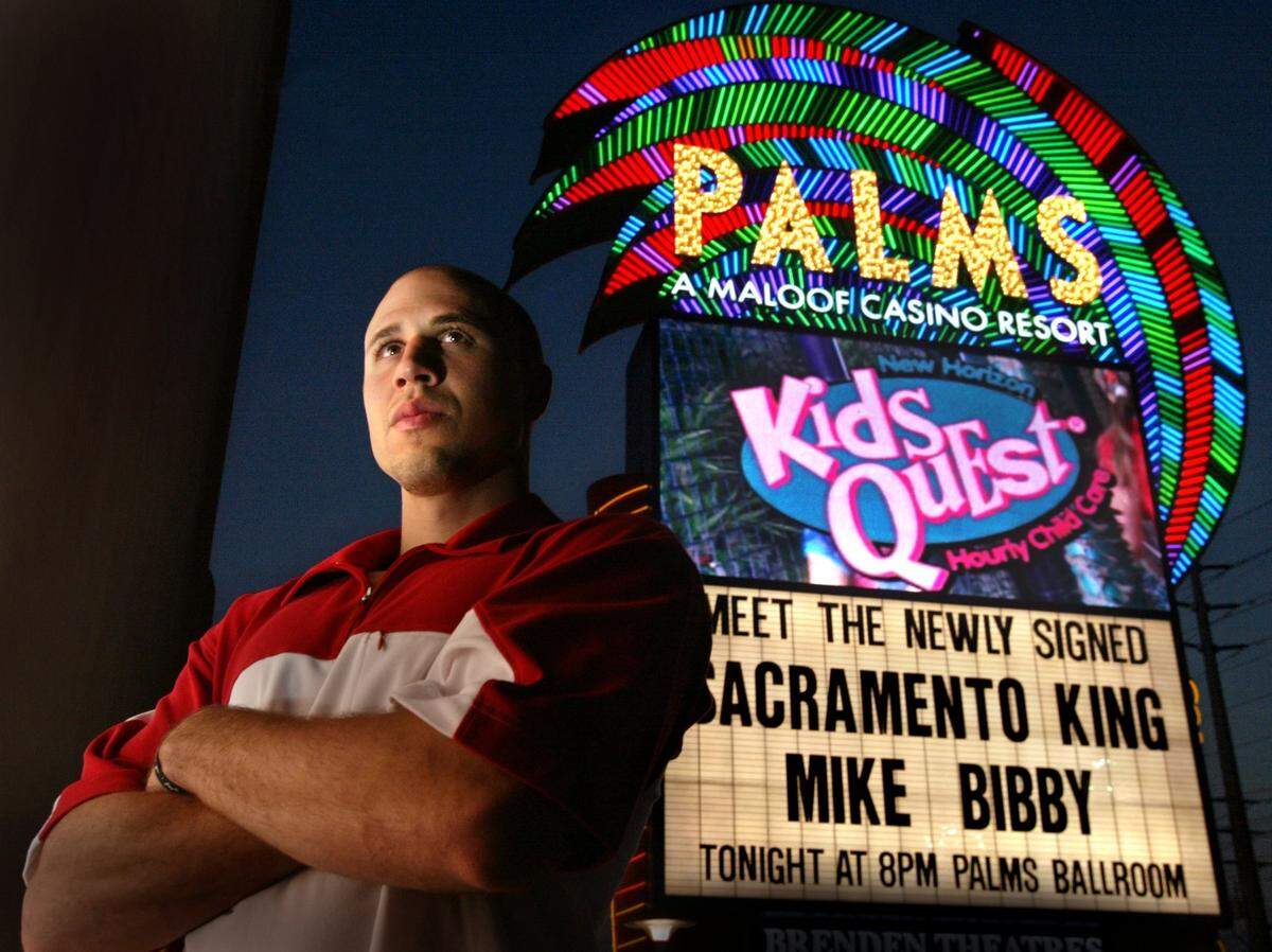 Mike Bibby stands in front of a sign at Palms Casino in Las Vegas introducing him as a Sacramento Kings player after signing an $80 million contract in 2002. The Maloof family that owned the team at the time also owned the casino.