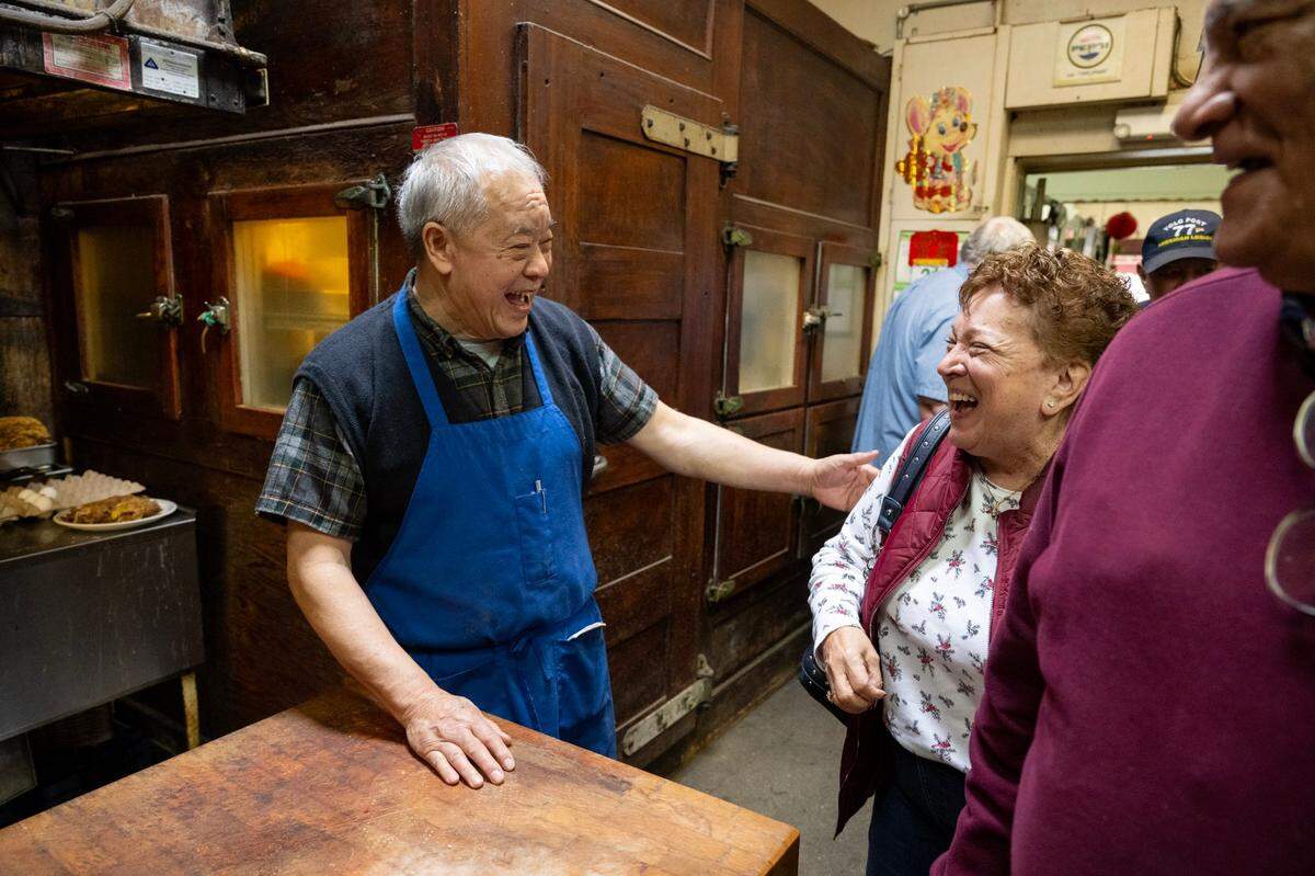 Chicago Cafe owner Paul Fong thanks longtime customers Frances and Melton Losoya, who walk past the restaurant’s 100-year-old refrigerator as they leave through the kitchen after a meal last month.